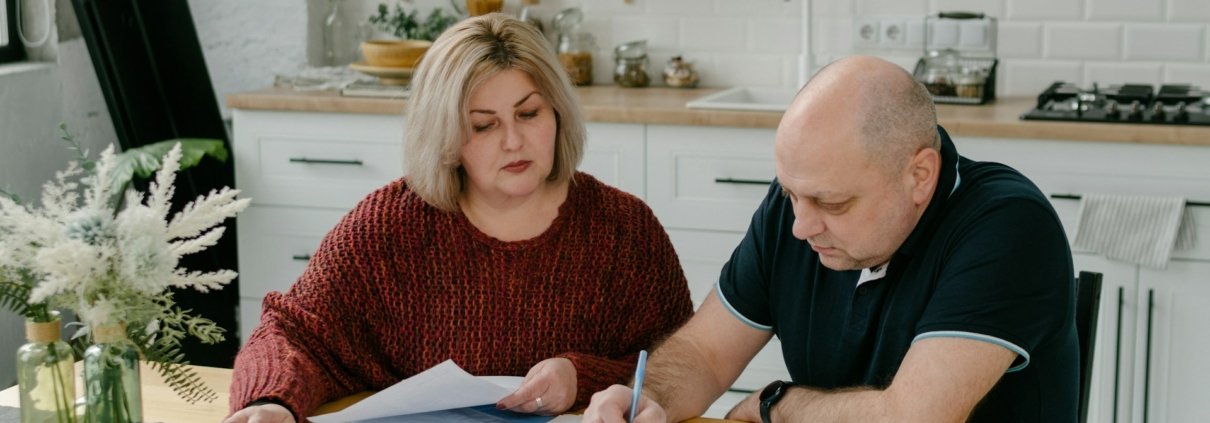 Pareja en la cocina revisando notas para cambiar el patrón de discusión